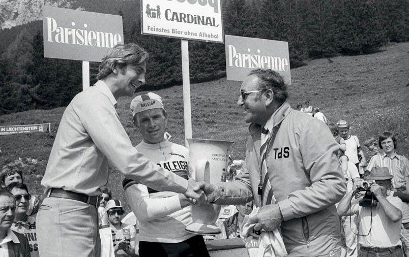 Op 12 juni 1976 wint Hennie Kuiper in Vaduz, de hoofdstad van het vorstendom Liechtenstein, de derde etappe van de Ronde van Zwitserland en legt daarmee de basis voor de eindzege. Op het podium wordt hij gefeliciteerd door kroonprins Johannes Adam Ferdinand Alois Josef Maria Marko d’Aviano Pius (links, tegenwoordig vorst van Liechtenstein) en Sepp Vögeli, de koersdirecteur van de ‘vierde grote ronde’